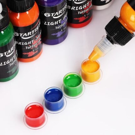Tattoo ink being dispensed into ink caps from 1 oz bottles